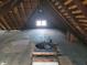 This attic has exposed rafters, a light-filled window, and an attic fan at 509 E Columbus St, Martinsville, IN 46151