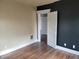 Bedroom featuring neutral and black accent walls, white trim, hardwood floors and a door at 509 E Columbus St, Martinsville, IN 46151