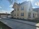 Side view of a yellow two-story home with a long driveway and detached garage at 509 E Columbus St, Martinsville, IN 46151