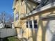 Side exterior shot of yellow home, white fence, and greenery at 509 E Columbus St, Martinsville, IN 46151