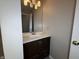 Bathroom vanity with a dark wood cabinet, white countertop, and large mirror at 5814 Lakefield Dr, Indianapolis, IN 46254
