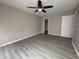 Bedroom boasting wood-look floors, tan walls, ceiling fan, and two doors at 5814 Lakefield Dr, Indianapolis, IN 46254