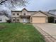 Charming two-story home features a two-car garage, manicured lawn, and inviting curb appeal at 5814 Lakefield Dr, Indianapolis, IN 46254