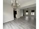 Open living room with hardwood floors, stylish light fixtures, and seamless flow into the kitchen at 5814 Lakefield Dr, Indianapolis, IN 46254