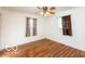 Bedroom featuring hardwood floors, neutral walls, two windows, and ceiling fan with lights at 5838 W Henry St, Indianapolis, IN 46241