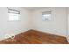 Cozy bedroom featuring hardwood floors, neutral walls, and two windows with blinds at 5838 W Henry St, Indianapolis, IN 46241