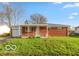 Charming single-story brick home with covered front porch and well-maintained lawn at 5838 W Henry St, Indianapolis, IN 46241