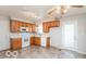 Bright kitchen with wooden cabinets, white countertops, range, tile floors, and stainless steel sink at 5838 W Henry St, Indianapolis, IN 46241