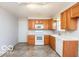 Well-lit kitchen featuring wood cabinetry, a microwave, tile floor, and a white dishwasher at 5838 W Henry St, Indianapolis, IN 46241