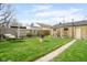 Lush backyard features a well-maintained lawn, a charming garage, and a stone pathway, perfect for relaxation at 616 N Bancroft St, Indianapolis, IN 46201