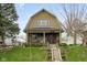 Attractive two-story house featuring a welcoming front porch and well-maintained landscaping, enhancing curb appeal at 616 N Bancroft St, Indianapolis, IN 46201