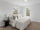 Beautiful bedroom features a cozy bed with natural light from two windows at 625 N Parker Ave, Indianapolis, IN 46201