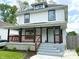 Charming two-story home with a covered front porch, black accents, and landscaped yard at 625 N Parker Ave, Indianapolis, IN 46201