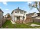 Rear exterior view featuring a wooden deck, grassy yard, and charming white two-story home at 625 N Parker Ave, Indianapolis, IN 46201