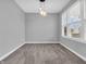 Neutral bedroom with carpet, a modern light fixture, and a bright window, providing a comfortable and serene space at 682 Keswick Dr, Brownsburg, IN 46112