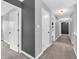 Hallway with neutral carpet and paint leads to various rooms, with doors and lighting at 682 Keswick Dr, Brownsburg, IN 46112