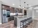Modern kitchen with stainless steel appliances, granite countertops, and an island with seating at 682 Keswick Dr, Brownsburg, IN 46112