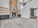 Bright living room featuring a stone fireplace, floating shelves, and modern lighting fixture at 682 Keswick Dr, Brownsburg, IN 46112