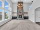 Stunning living room with a stone fireplace, large windows, built-ins, and soaring ceilings for cozy gatherings at 682 Keswick Dr, Brownsburg, IN 46112