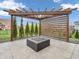 This backyard patio features a modern pergola shading a concrete patio with a decorative fire pit at 682 Keswick Dr, Brownsburg, IN 46112