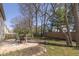 Backyard featuring a concrete patio seating area, tall shade trees, and a wood fence at 6853 Bretton Wood Dr, Indianapolis, IN 46268