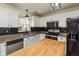 Modern kitchen with stainless steel appliances, a butcher block island, and white cabinetry at 6853 Bretton Wood Dr, Indianapolis, IN 46268