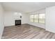 Bright living room featuring a cozy fireplace, large windows, and modern flooring at 6853 Bretton Wood Dr, Indianapolis, IN 46268
