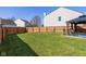 Grassy backyard featuring a wood privacy fence and a covered patio at 6953 Beargrass Ct, Indianapolis, IN 46241
