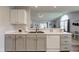 Open concept kitchen features gray cabinets, a stainless steel sink, and views of the home's living area at 7150 Brant Pointe Cir, Indianapolis, IN 46217