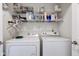 Bright laundry room featuring full-sized washer and dryer with shelving above at 7150 Brant Pointe Cir, Indianapolis, IN 46217