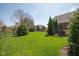 Manicured backyard boasts lush green grass and mature trees, providing a serene outdoor setting at 7322 Franklin Parke Ct, Indianapolis, IN 46259