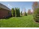 Well-maintained backyard showcases a green lawn and decorative trees, creating a peaceful retreat at 7322 Franklin Parke Ct, Indianapolis, IN 46259