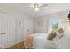 Bright bedroom featuring a ceiling fan, two closets, and a window with sheer curtains at 7322 Franklin Parke Ct, Indianapolis, IN 46259