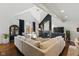 Bright living room features high ceilings, fireplace, large sectional sofa, and oversized arched window at 7322 Franklin Parke Ct, Indianapolis, IN 46259