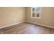 This bedroom features neutral walls, wood-look flooring, and a window that allows natural light into the room at 745 W Banta Rd, Indianapolis, IN 46217