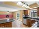 Modern kitchen with granite counters, wood cabinets, tile backsplash, and views into the living room at 745 W Banta Rd, Indianapolis, IN 46217
