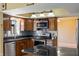 Kitchen with stainless appliances, granite counters, wood cabinetry, and a view of the living area at 745 W Banta Rd, Indianapolis, IN 46217
