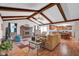 Spacious living area featuring wood beams, brick fireplace, and seamless flow into the modern kitchen at 758 Stafford Rd, Plainfield, IN 46168