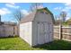 Outdoor shed with shingled roof and double doors for backyard storage at 758 Stafford Rd, Plainfield, IN 46168