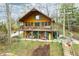 Charming log cabin home featuring a spacious porch and balcony, set against a picturesque backdrop of trees and natural beauty at 7591 Inkbush Dr, Nineveh, IN 46164