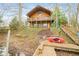 Exterior view of a charming log cabin from the waterfront dock, showcasing its rustic appeal and lakeside setting at 7591 Inkbush Dr, Nineveh, IN 46164