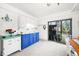 Charming kitchen with blue cabinets, white appliances, and a sliding glass door to the backyard at 7591 Inkbush Dr, Nineveh, IN 46164