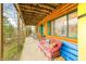 Inviting porch with wood beams, seating and log-cabin exterior featuring green trim and a view of nature at 7591 Inkbush Dr, Nineveh, IN 46164