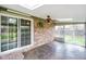 Bright sunroom featuring tile flooring, brick accent wall, skylights, and sliding doors to the outdoors at 7714 Kenneth Ct, Brownsburg, IN 46112