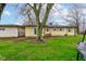 View of the home exterior with a spacious backyard featuring healthy green grass and mature trees at 7764 S State Road 109, Markleville, IN 46056