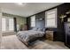 Bedroom with a cozy bed, dresser, and large windows, enhanced by dark accent wall at 7764 S State Road 109, Markleville, IN 46056