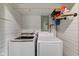 Close up on closet laundry room featuring two Samsung washing machines and shelf storage at 7764 S State Road 109, Markleville, IN 46056