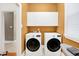 Functional laundry room with modern washer and dryer, overhead cabinets, and natural light at 8040 Lynch Ln, Indianapolis, IN 46250