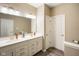 Bright bathroom featuring a double sink vanity, large mirror, and a toilet in a separate area at 8160 Nik St, Brownsburg, IN 46112