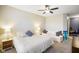 Spacious bedroom with a ceiling fan, a queen bed and a white sofa, illuminated by lamps at 8160 Nik St, Brownsburg, IN 46112